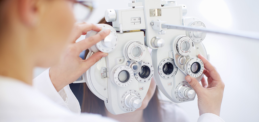 Bild eines Optikers, welcher das Sehtestgerät einstellt.